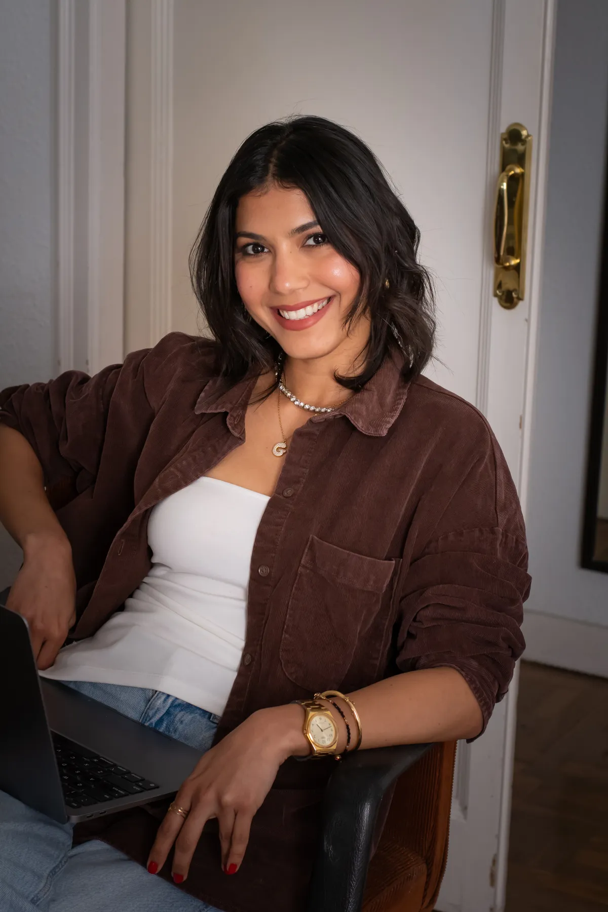 Giulia Da Silva smiling, sitting with her laptop
