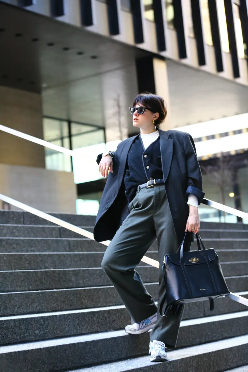 Woman in a tailored suit and sneakers on city steps