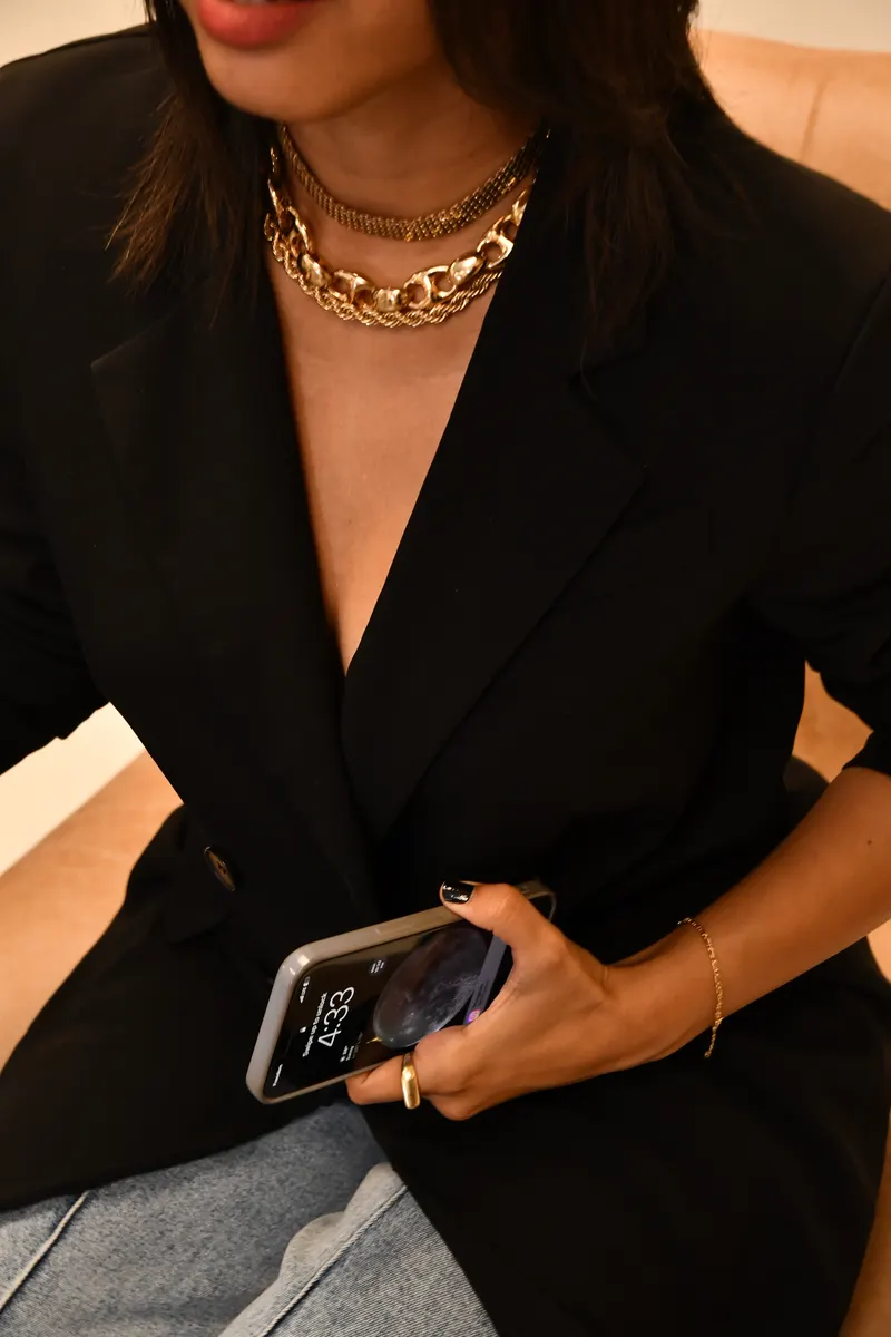 Close-up of a black blazer with a gold chain necklace